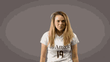 a woman wearing a white los angeles jersey with the number 19 on it