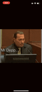 a man in a suit is giving a speech and the word no is on the screen