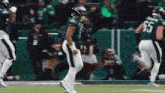 a group of football players are dancing on a field .