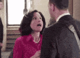 a man and a woman are standing next to each other in a room .
