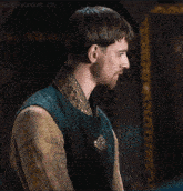a man with a beard is wearing a green vest with a gold collar