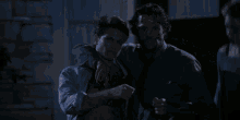 two men standing next to each other in the dark