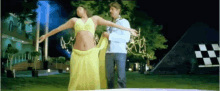a woman in a yellow dress is dancing with a man in a blue jacket .