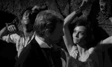 a man and a woman are chained to a wall and talking to each other .