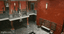 a person is hanging from a balcony in an empty room .