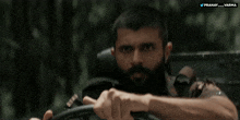 a man with a beard is driving a vehicle with the twitter username pranavarma