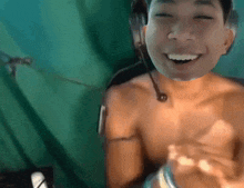 a shirtless man with a headset around his neck