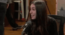 a woman is talking into a microphone in a room .