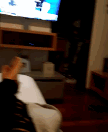 a blurry picture of a person laying on a bed in front of a flat screen tv