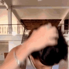 a person with a ring on their finger is holding their hair