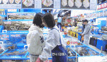 a woman wearing a sweatshirt that says ' abercrombie & fitch ' on it talks to another woman