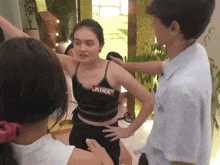 a woman in a black tank top has a name tag that says kira