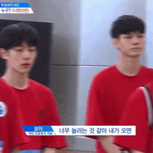 a blurry picture of two young men in red shirts