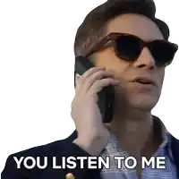 a man wearing sunglasses is talking on a cell phone and has the words you listen to me written below him