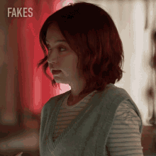 a woman with red hair is standing in front of fakes