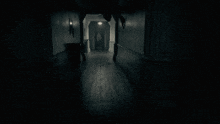 a dark hallway with a person hanging upside down from the ceiling