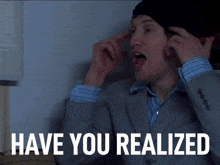 a man wearing a suit and a beanie says " have you realized "
