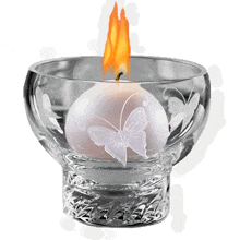 a candle with a butterfly on it in a glass