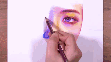 a person is drawing a woman 's eye with a pencil