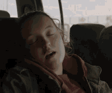 a young girl is sleeping in a car seat with her eyes closed