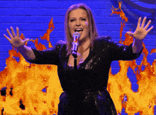 a woman singing into a microphone with the letter t on it