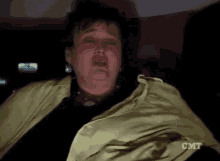 a woman in a yellow jacket is crying with cmt written on her shirt