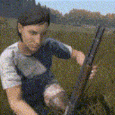 a man is holding a shotgun in a field of grass .