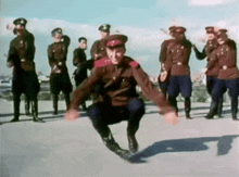 a group of men in military uniforms are dancing on a street