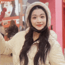 a woman wearing a white hat with cat ears and a black face mask
