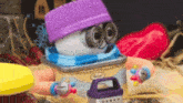 a cartoon character wearing a purple hat and scarf is sitting on a table .