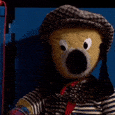 a stuffed animal wearing a hat and a bow tie