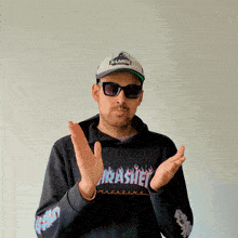 a man wearing sunglasses and a thrasher magazine shirt