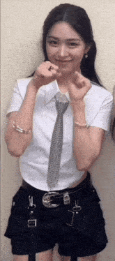 a woman wearing a white shirt and black shorts is smiling