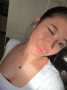 a girl wearing a white shirt and a necklace with a butterfly pendant