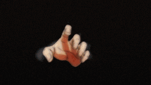 a close up of a person 's hand reaching out in the dark