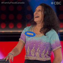 a woman with a name tag that says sarita is laughing