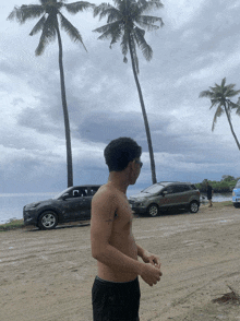 a shirtless man is standing in front of a row of cars