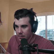 a man wearing headphones is talking into a microphone .