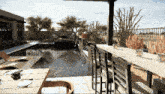 a computer generated image of a pool with a table and chairs in front of it