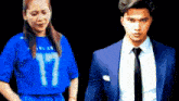 a man in a suit and tie stands next to a woman wearing a blue shirt with the number 17 on it