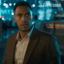 a man in a suit stands in front of a countdown sign