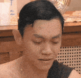 a close up of a man 's face with his eyes closed and a bottle of only star in the background