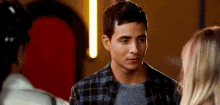a man in a plaid shirt looks at a woman