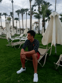 a man in a polka dot shirt is sitting on a lounge chair