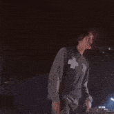 a man in a gray shirt is dancing in the dark