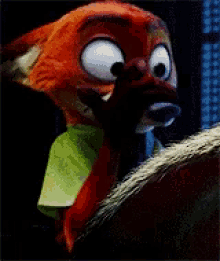 a close up of a stuffed animal with big eyes and a green shirt