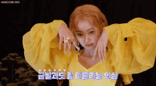 a woman wearing a yellow top has a ring on her finger and says honeycam.org