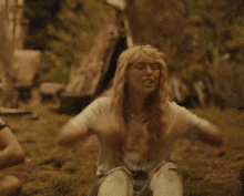 a woman with blonde hair is sitting on the ground