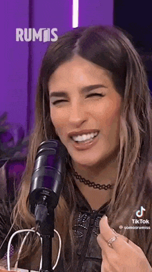 a woman is sitting in front of a microphone with her eyes closed .