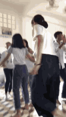 a group of people are dancing in a room in a classroom .